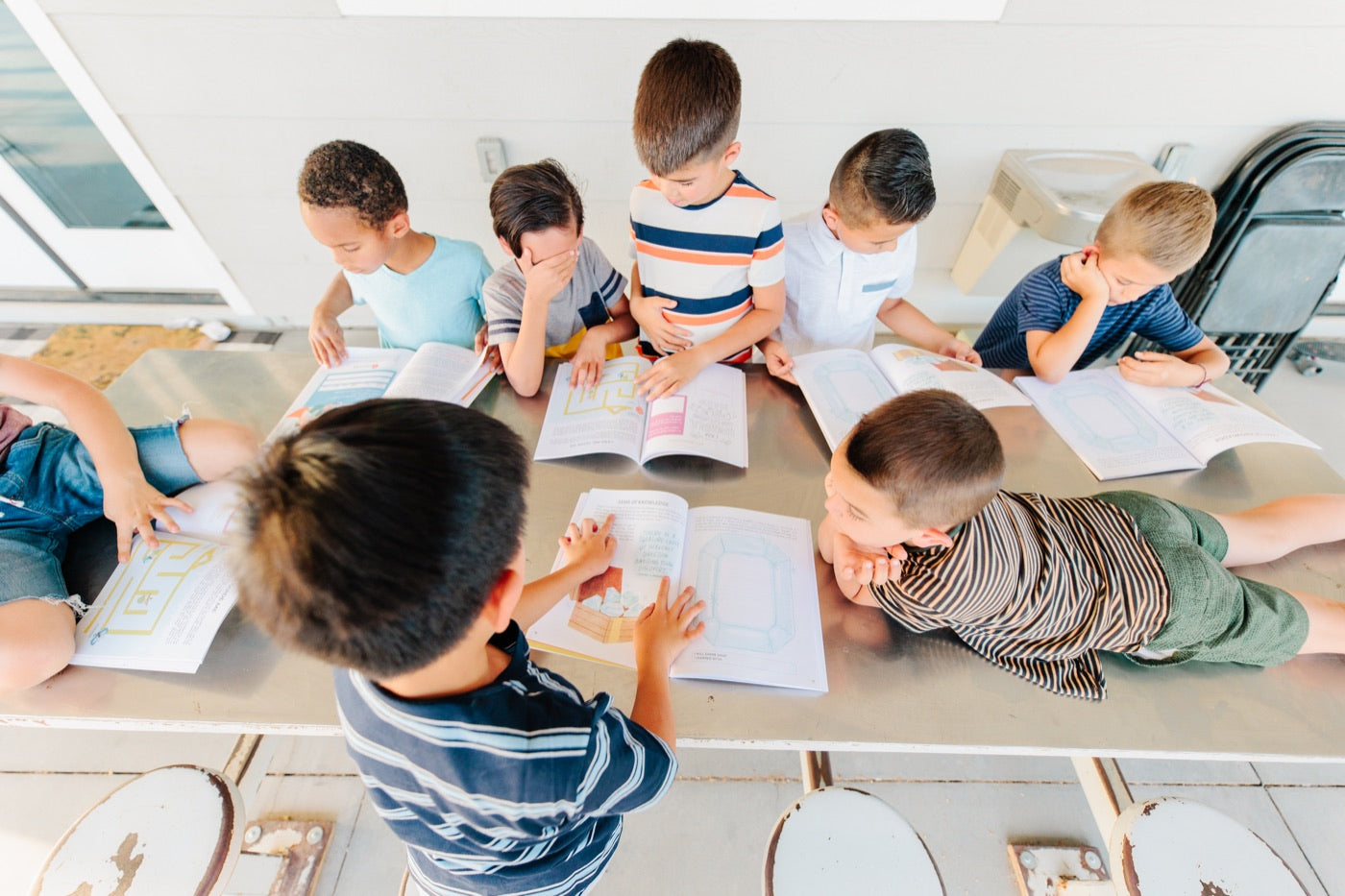 Children gathered around a table using As I Am activity books