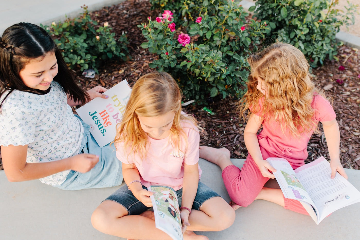 Three children reading As I Am together outside